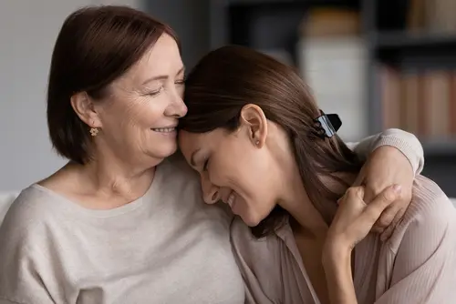 A woman and her mother smiling for the camera.